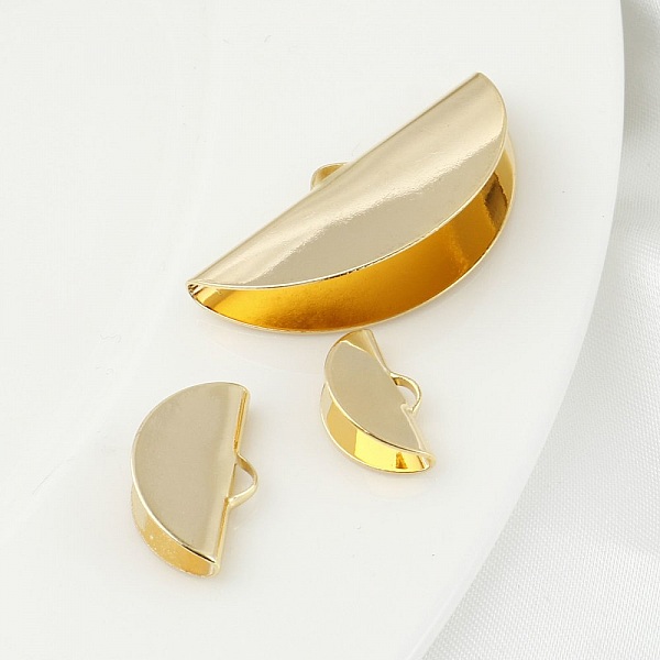 1 guldpl&auml;terad halvm&aring;ne med en infattning 35 x 18 mm