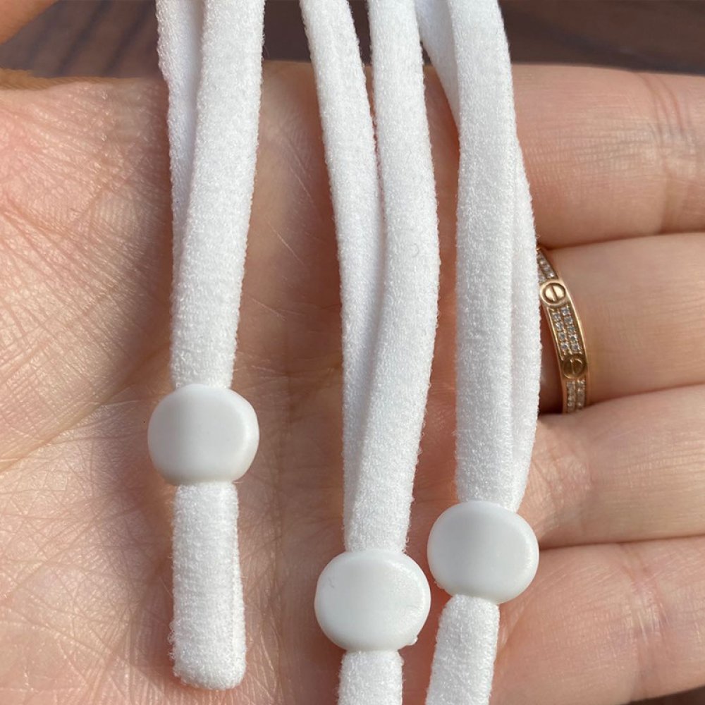 2 vita elastiska band med justerbar maskinfästningsögla.