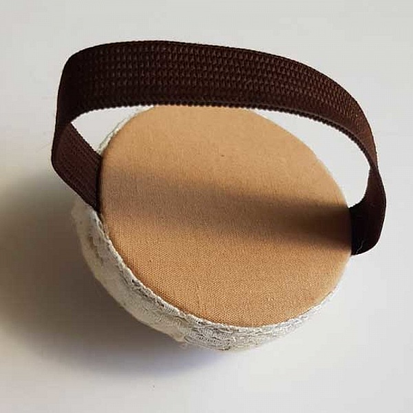 Bracelet porte-épingles avec élastique marron et coussin beige.