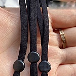 10 svarta elastiska band med justerbar maskinfästningsögla.