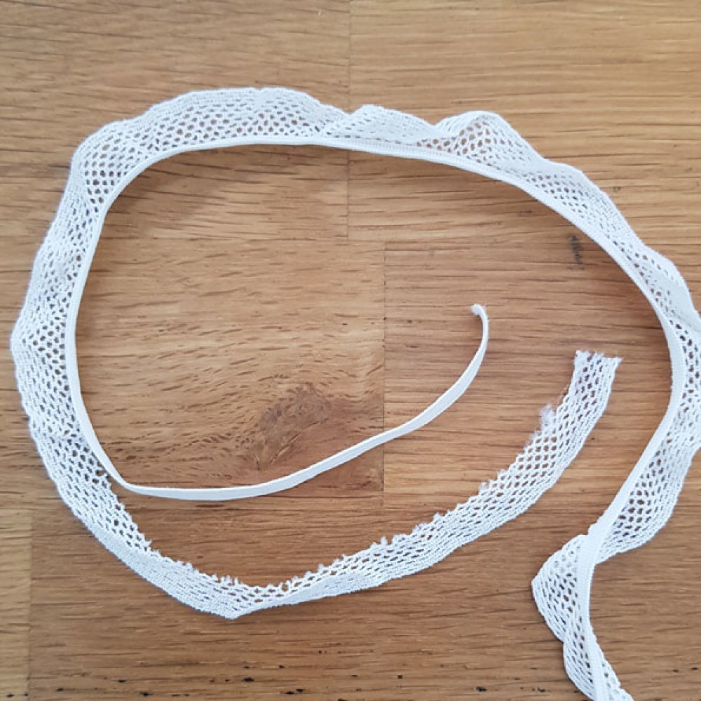 Vit elastisk 4,5 mm spets som ska sys