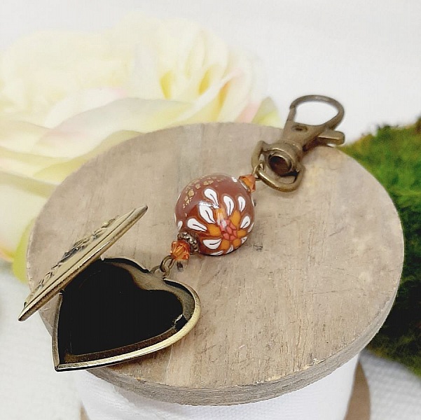 pedentisk nyckelring med foto och p&auml;rla i brun polymerlera och vit blomma. 