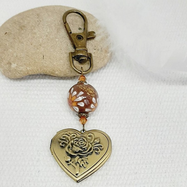 pedentisk nyckelring med foto och p&auml;rla i brun polymerlera och vit blomma. 