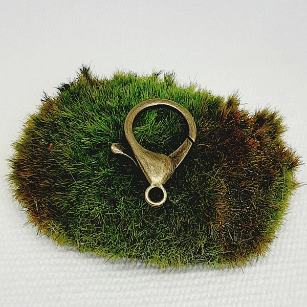 nyckelring h&auml;ngande med fotoh&aring;llare och gr&ouml;n och r&ouml;d polymerlera p&auml;rla