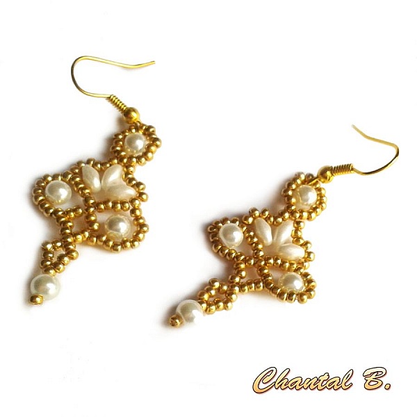 Boucles d'oreilles tissées en perles nacrées et détails dorés.