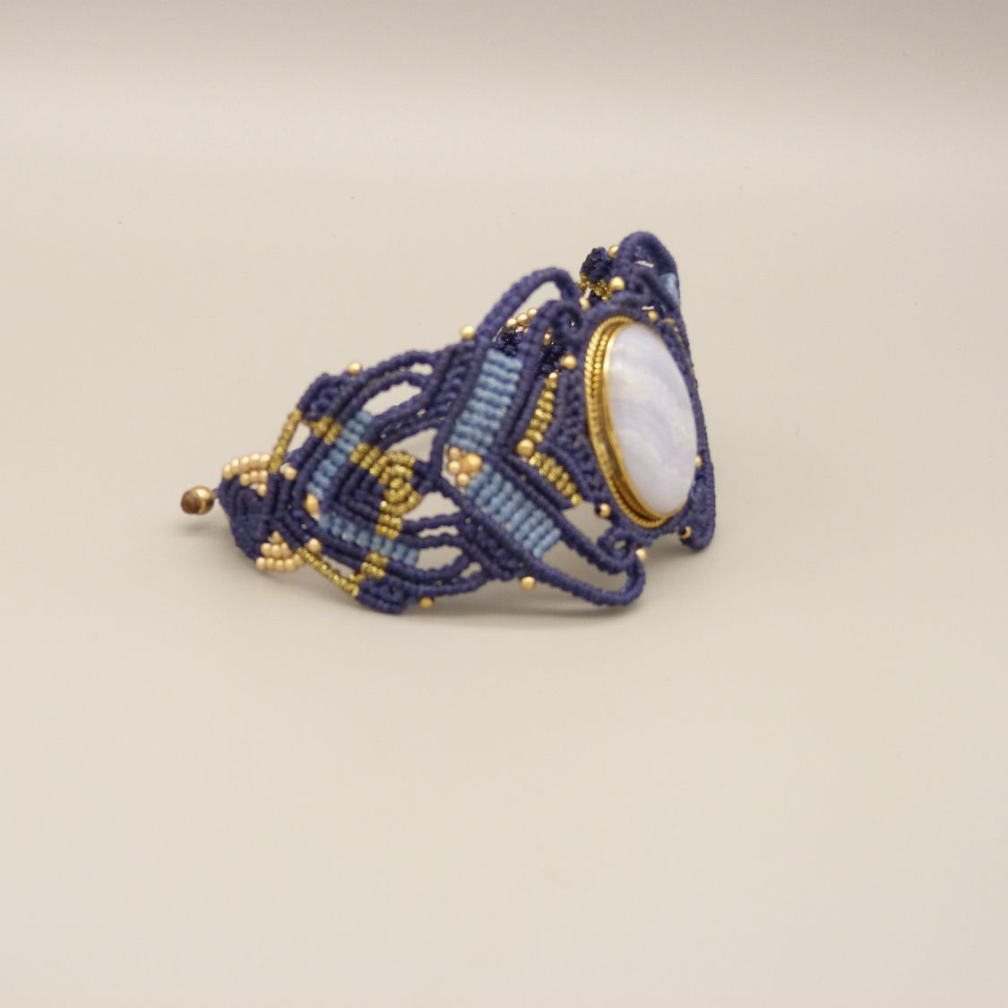 Midnattsblå mikro-macramé armband med en bandagat i guldmetall