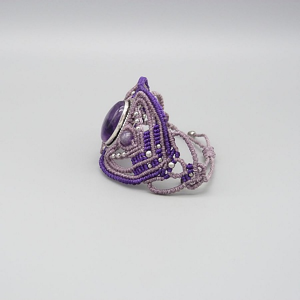 Lila mikro-macram&eacute; armband med en ametist i mitten