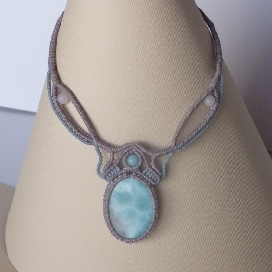 Halsband i taupegrå/frostat blå mikromakramé med en naturlig ädelsten i mjuka nyanser av vitt och ljusblått som mittpunkt.