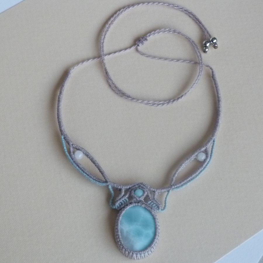 Halsband i taupegrå/frostat blå mikromakramé med en naturlig ädelsten i mjuka nyanser av vitt och ljusblått som mittpunkt.
