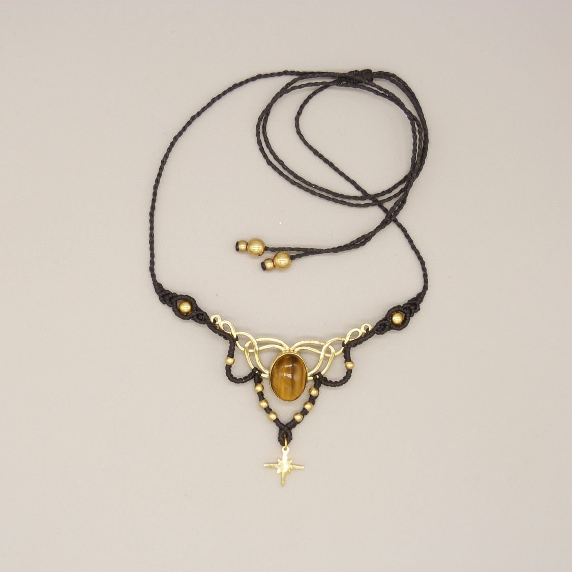 Svart halsband i mikro-macramé med ett tigeröga