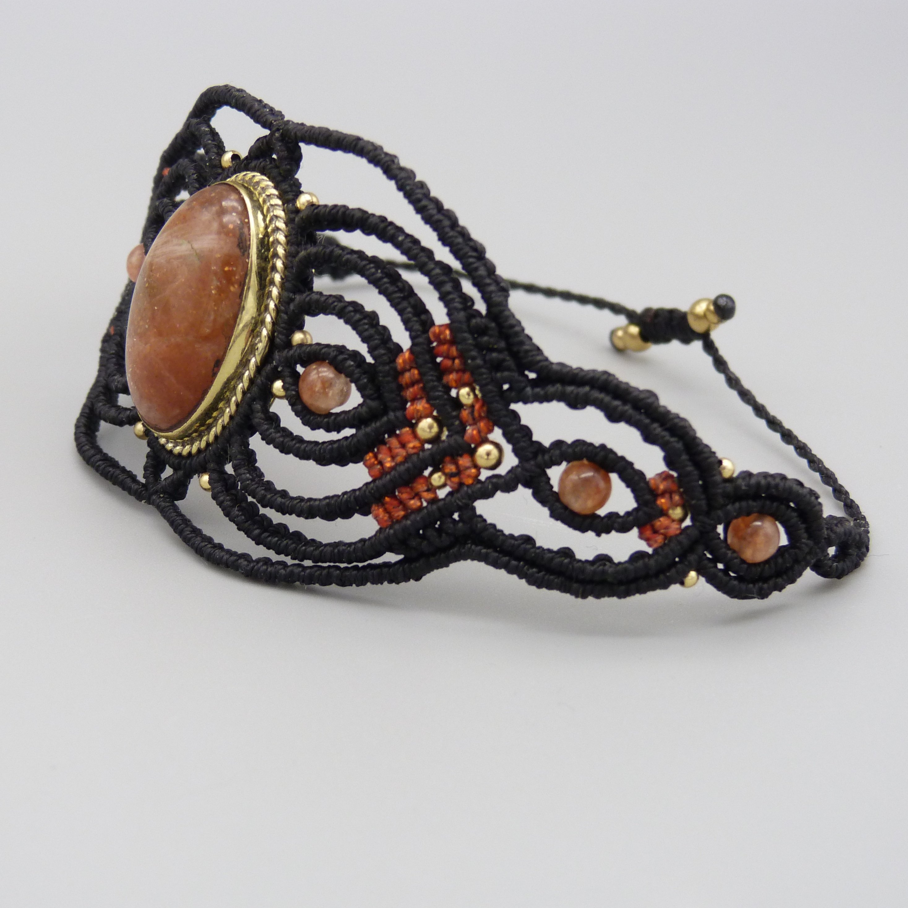 Manchette noire en micro-macram&eacute; avec une pierre de soleil