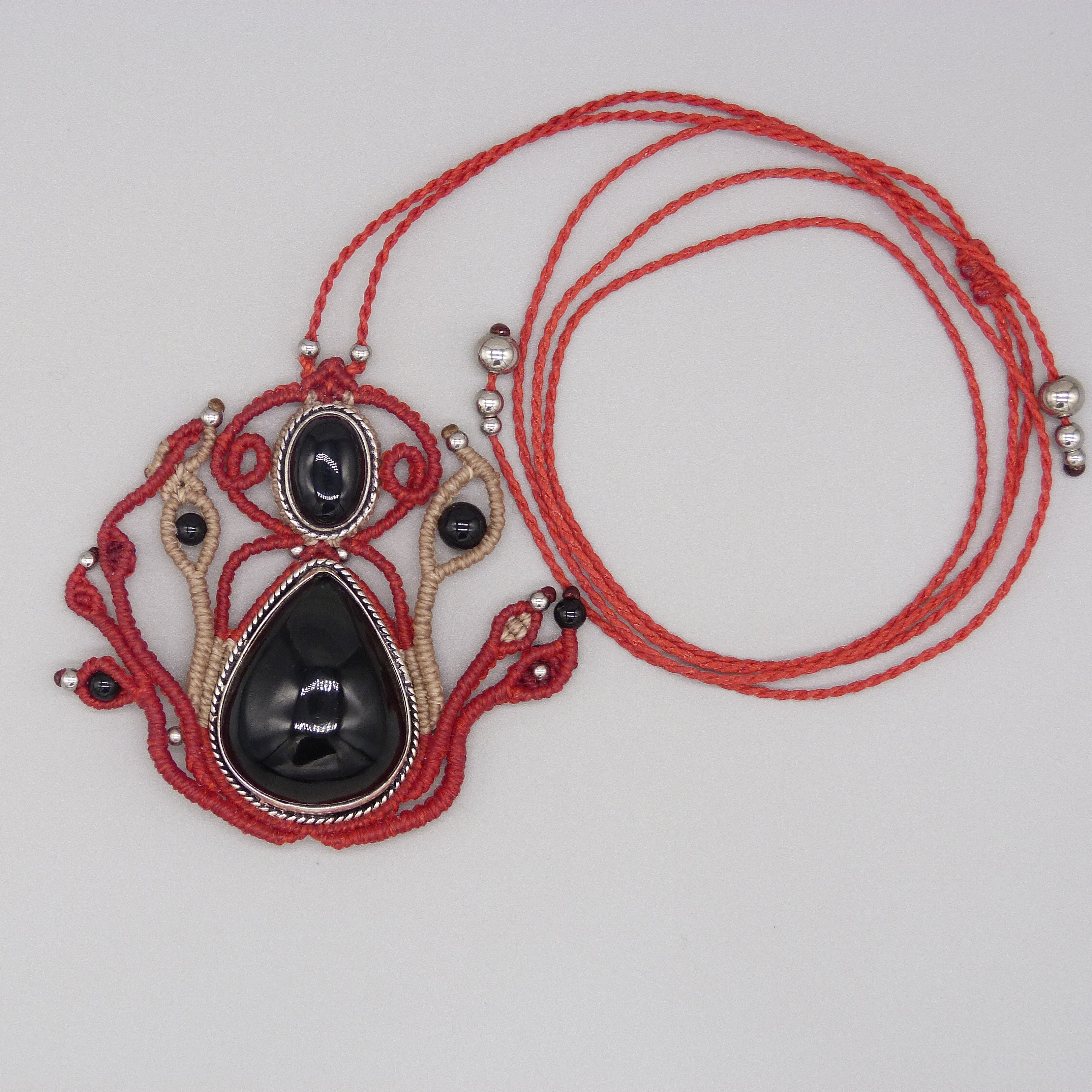 Sautoir en micro-macram&eacute; rouge avec une pierre onyx noire sertie de m&eacute;tal