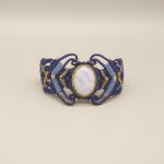 Midnattsblå mikro-macramé armband med en bandagat i guldmetall