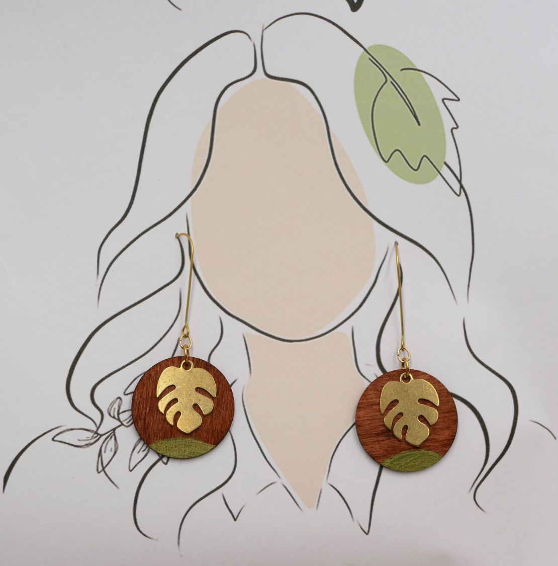 Örhängen av körsbärsträ och monstera blad i guldpläterad mässing.
