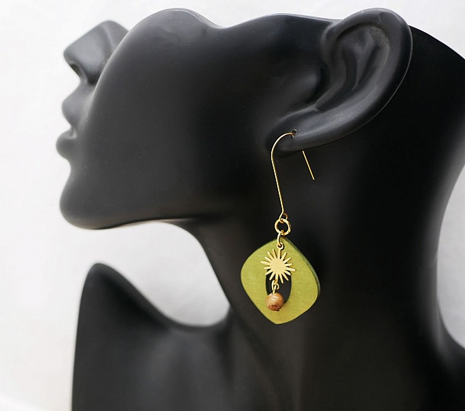 &Ouml;rh&auml;ngen i gr&ouml;nt metalliskt tr&auml; och gyllene sol i h&auml;ngande form