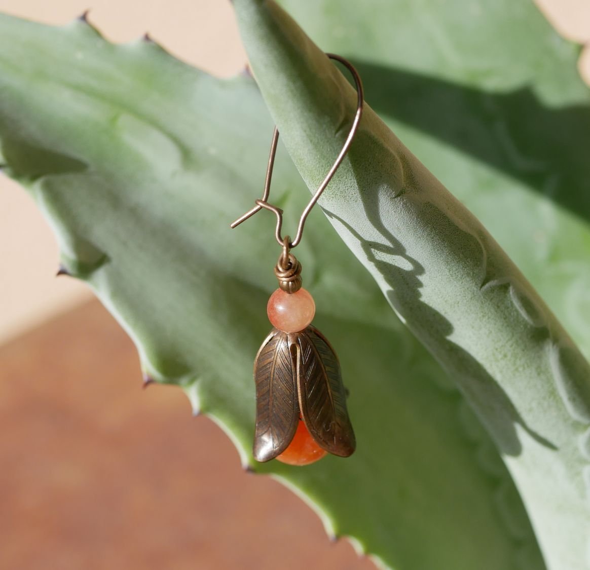 Örhängen i naturlig mässing och orange pärlor med kronblad