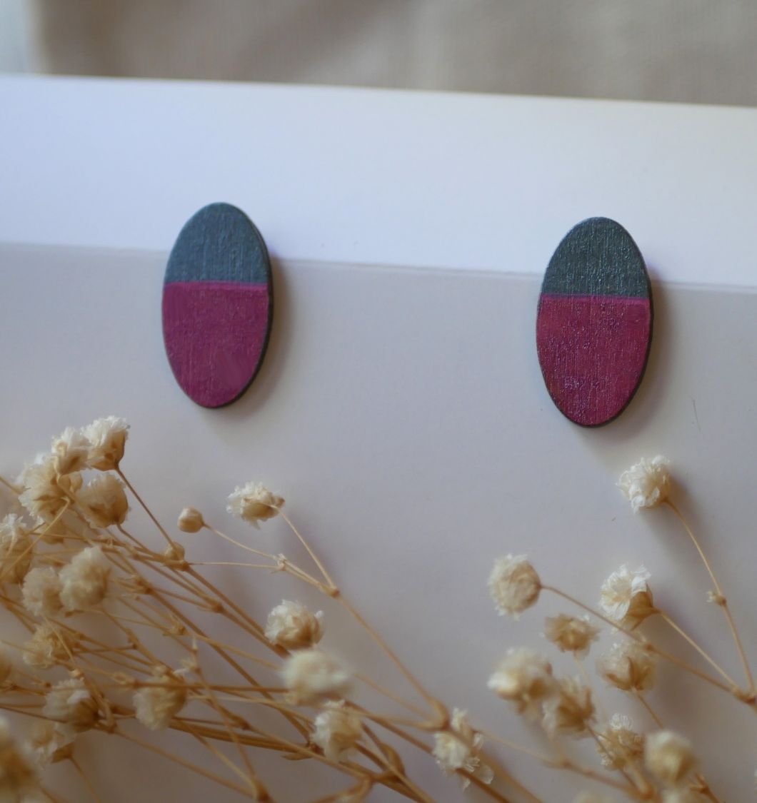 Ovala örhängen i trä målade i fuchsia och grå metallisk effekt.