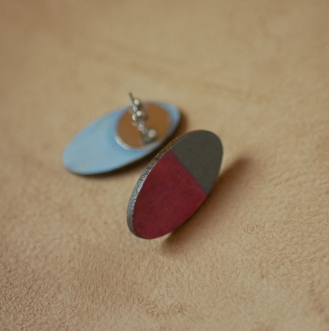 Ovala örhängen i trä målade i fuchsia och grå metallisk effekt.