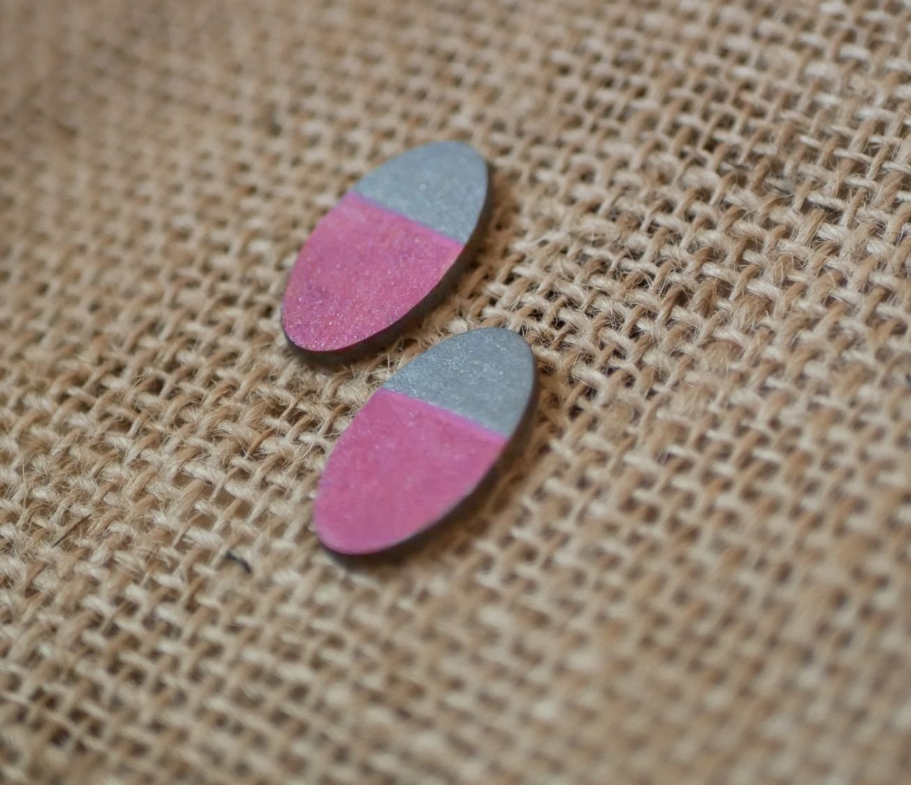 Ovala örhängen i trä målade i fuchsia och grå metallisk effekt.