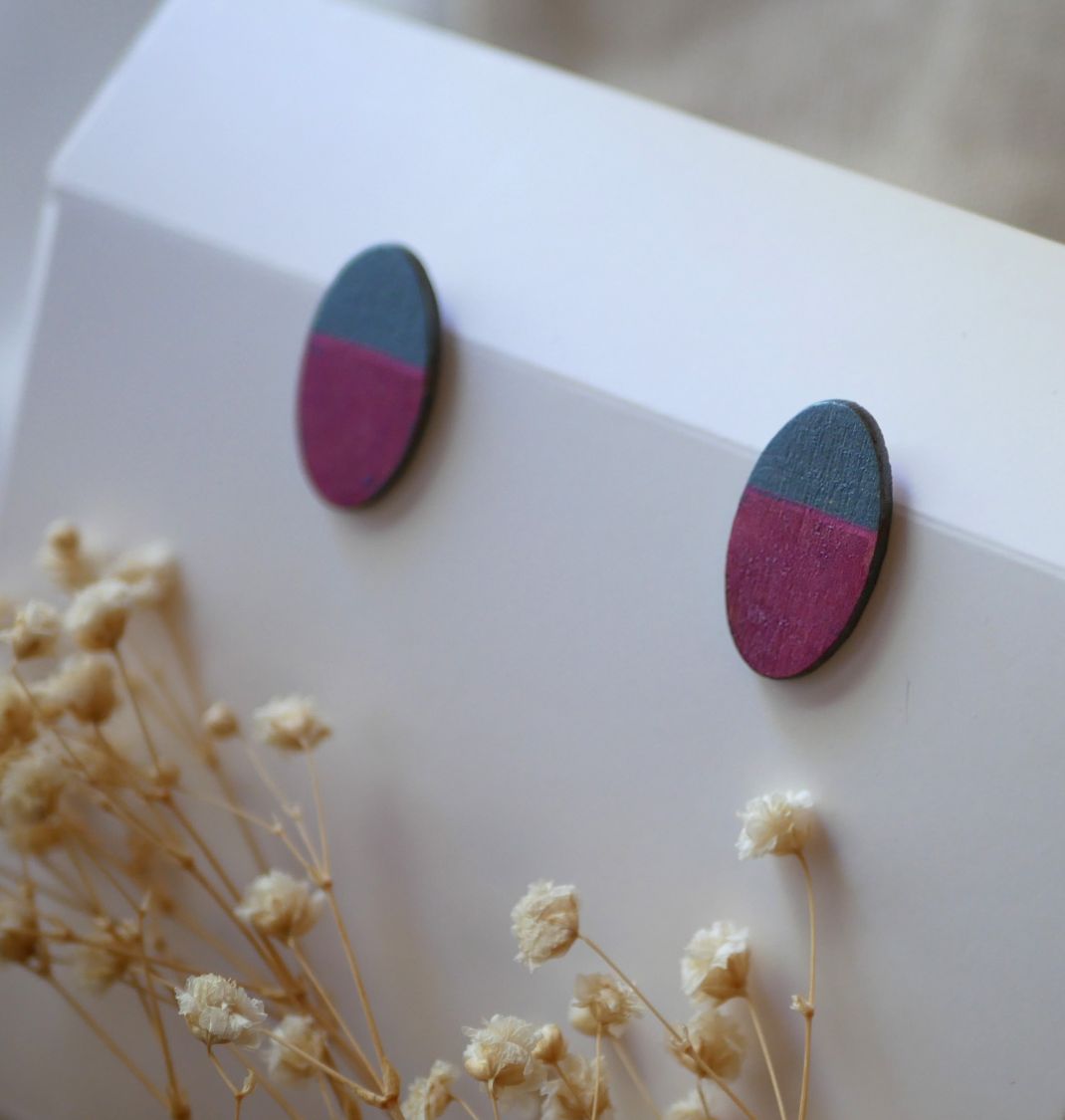 Ovala örhängen i trä målade i fuchsia och grå metallisk effekt.