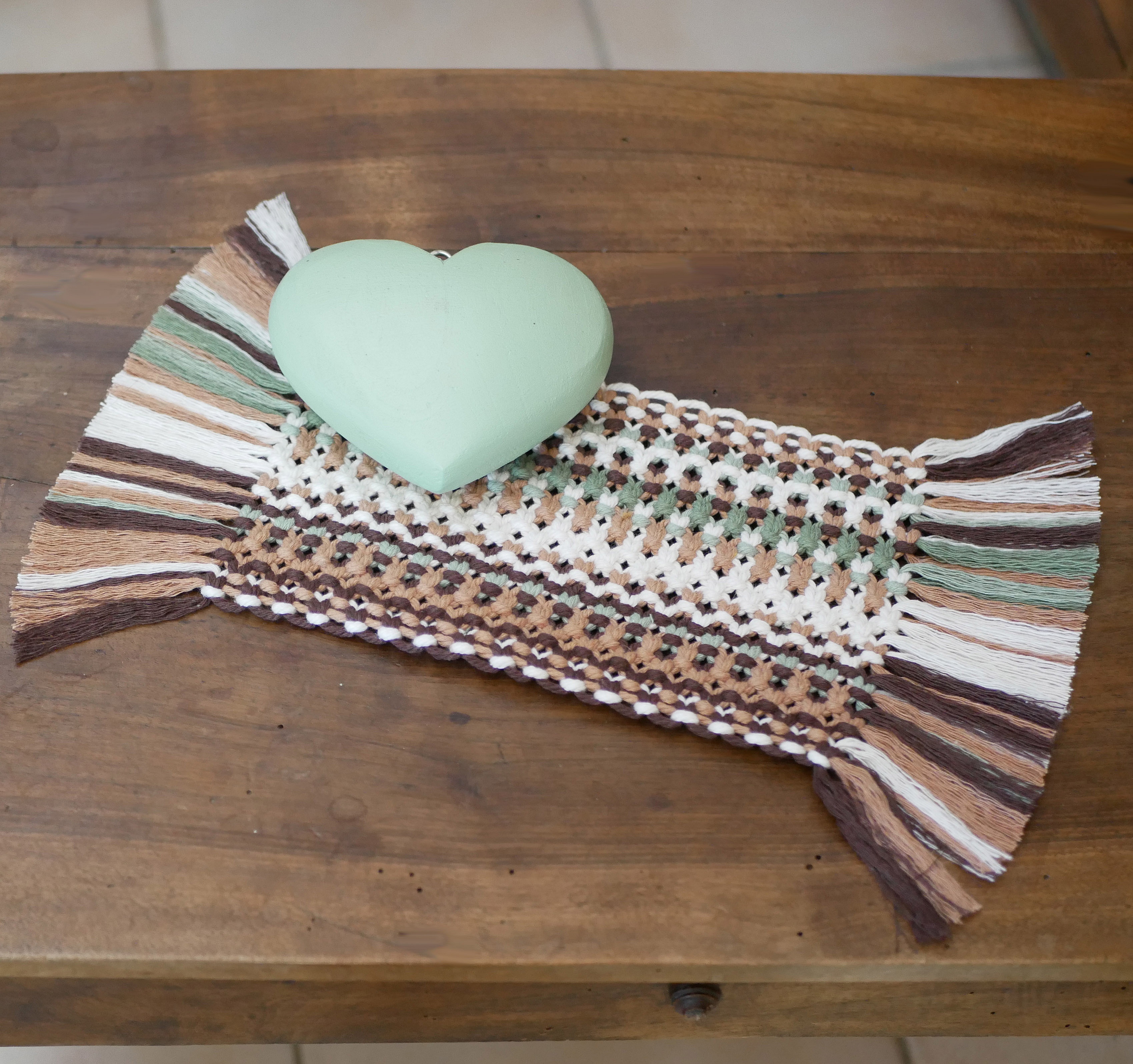 Set de table en macramé style forêt avec cœur décoratif.