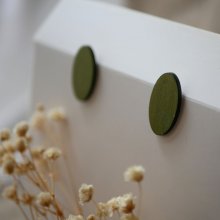 Ovala örhängen i trä målade i en duo av gröna färger med metallisk effekt.