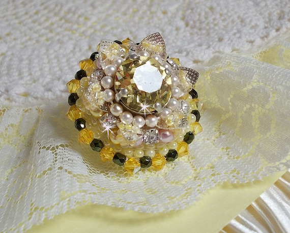 Blomsterring broderad med Swarovski-kristaller, runda pärlor, fröpärlor och ett ringstativ i 925/1000 silver.