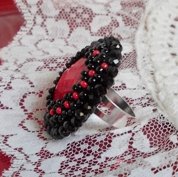 Midnight in Paris ring broderad med en röd facetterad cabochon och runda svarta pärlor.