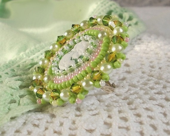 Anisse ring broderad med ett porträtt av en kvinna med rosor och Swarovskikristaller i cabochon av harts.