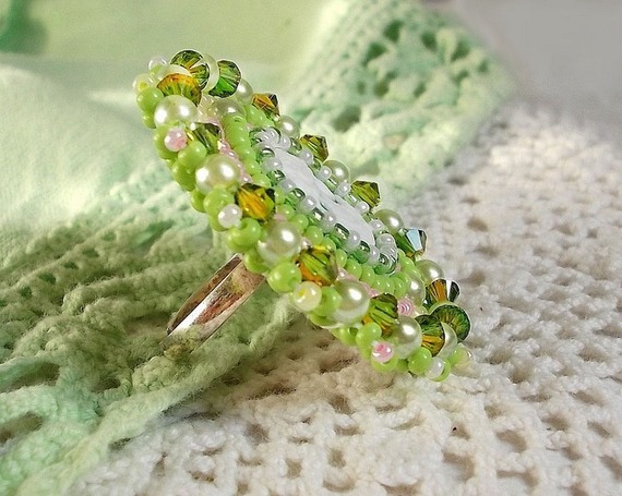 Anisse ring broderad med ett porträtt av en kvinna med rosor och Swarovskikristaller i cabochon av harts.