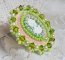 Anisse ring broderad med ett porträtt av en kvinna med rosor och Swarovskikristaller i cabochon av harts.