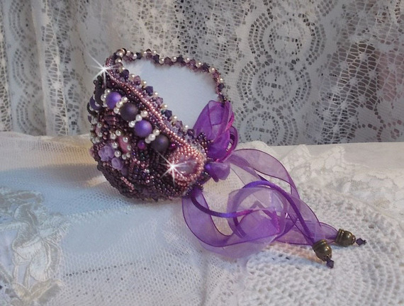 Kinesiskt armband med lila stenar broderat med fina stenar: sugiliter, Swarovskikristaller, fröpärlor och ett lila organzaband.