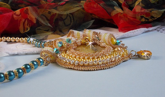 Haute-Couture Sunflower Gold-hänge broderat med 24 karat guldpläterade fröpärlor, en Madagaskar-opal och Swarovski-kristaller.