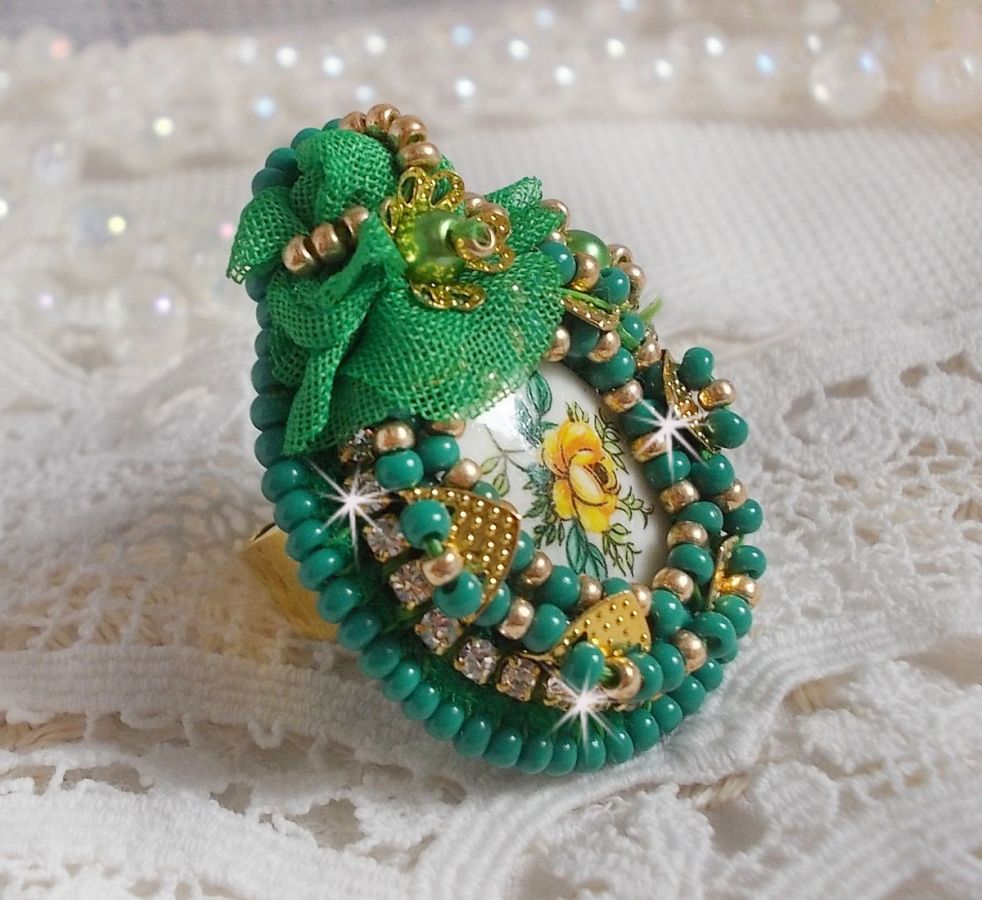 Vacker smaragd ring med en keramisk cabochon gjord av en gul och grön ros.