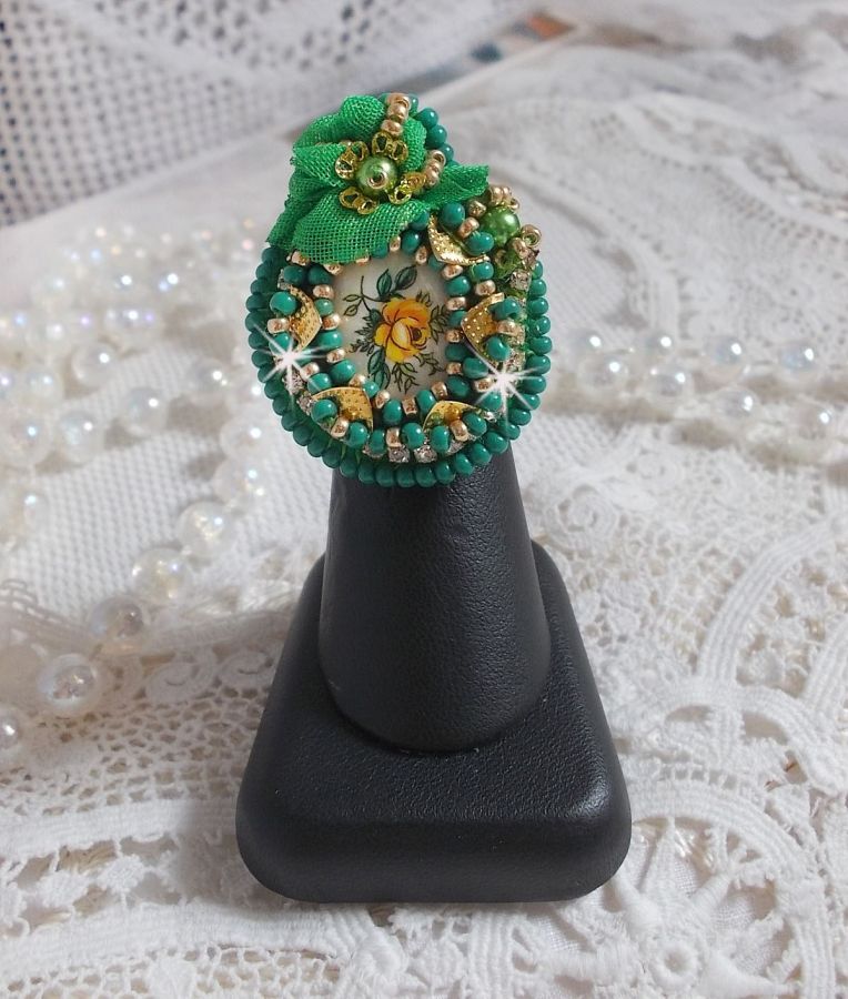 Vacker smaragd ring med en keramisk cabochon gjord av en gul och grön ros.