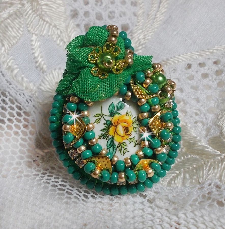 Vacker smaragd ring med en keramisk cabochon gjord av en gul och grön ros.