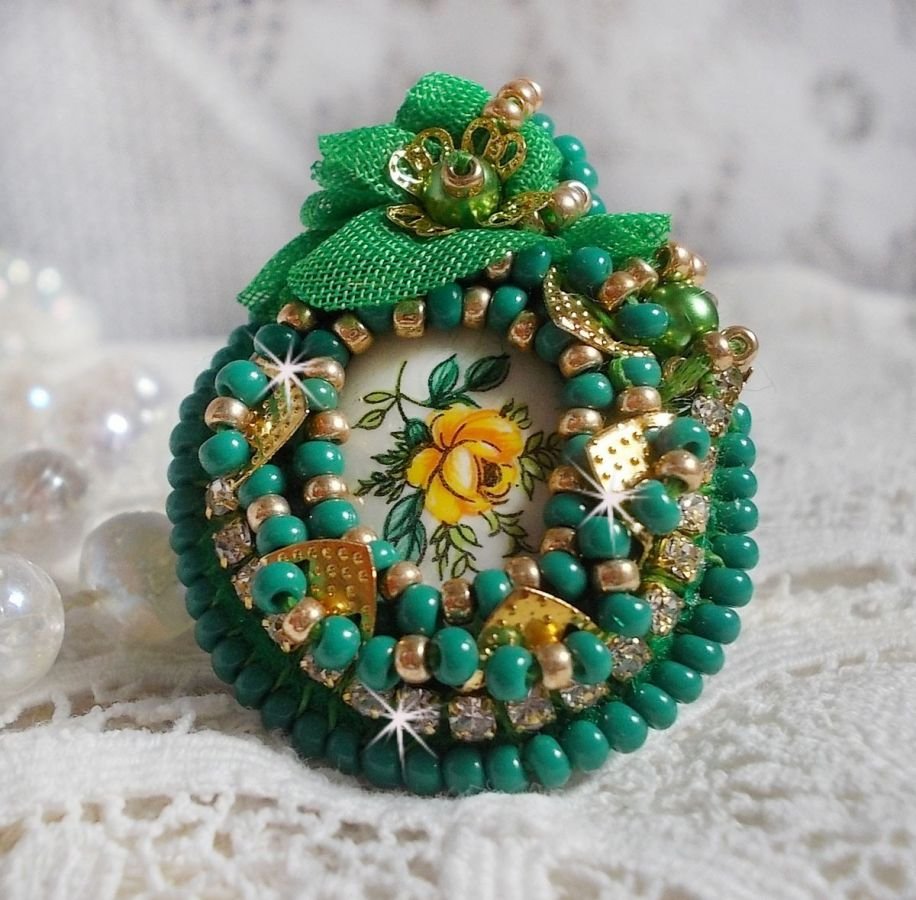 Vacker smaragd ring med en keramisk cabochon gjord av en gul och grön ros.