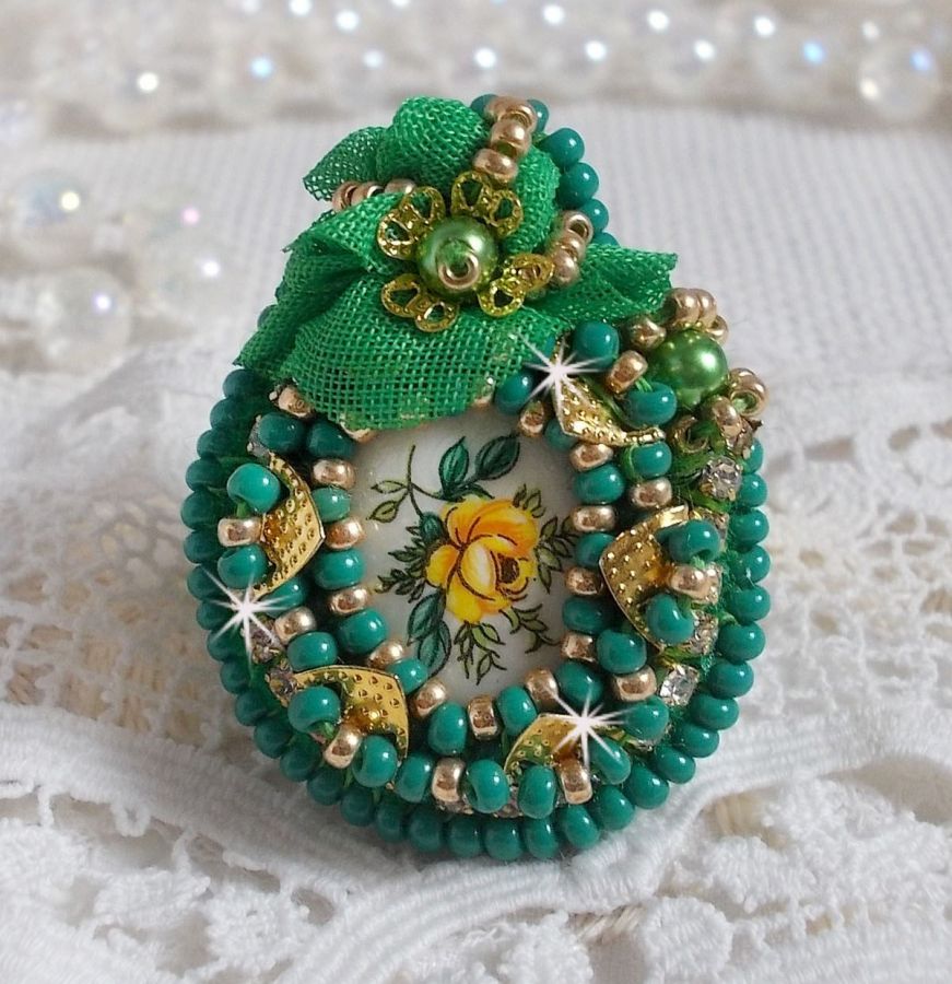 Vacker smaragd ring med en keramisk cabochon gjord av en gul och grön ros.