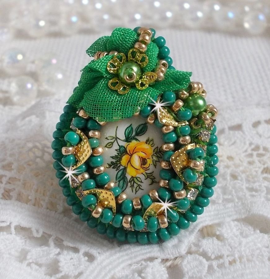 Vacker smaragd ring med en keramisk cabochon gjord av en gul och grön ros.