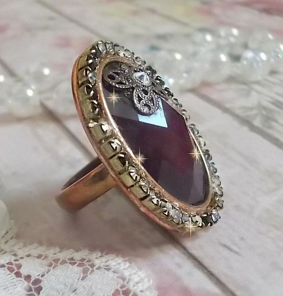 Chic burgundy ring skapad med PureCrystal kristaller, en blommaformad st&auml;mpel och en glascabochon.