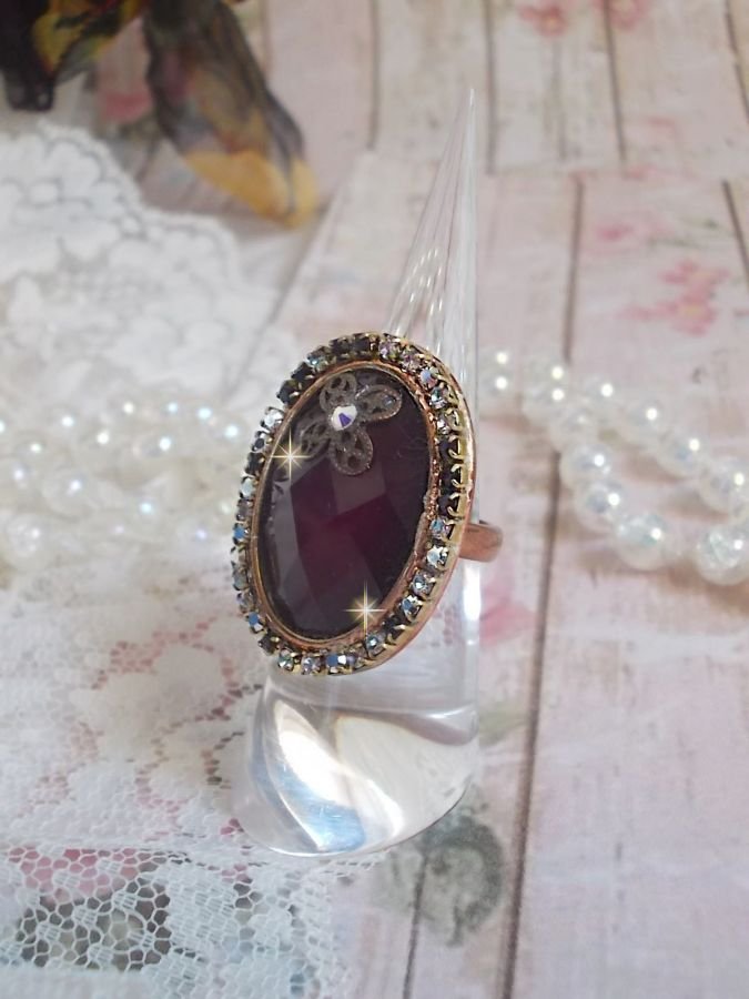 Chic burgundy ring skapad med PureCrystal kristaller, en blommaformad stämpel och en glascabochon.