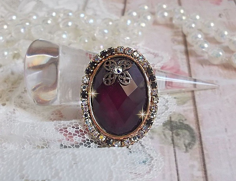 Chic burgundy ring skapad med PureCrystal kristaller, en blommaformad st&auml;mpel och en glascabochon.