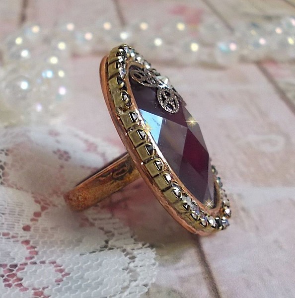Chic burgundy ring skapad med PureCrystal kristaller, en blommaformad st&auml;mpel och en glascabochon.