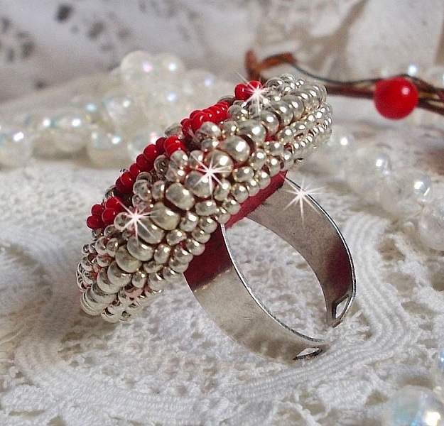 Drigon Red ring broderad med en r&ouml;d Swarovski-kristallcabochon, silverb&auml;lten och fr&ouml;p&auml;rlor.