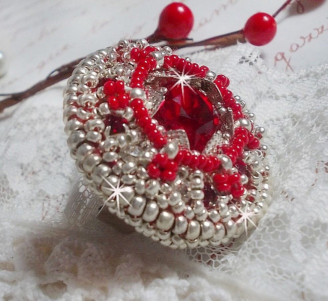 Drigon Red ring broderad med en r&ouml;d Swarovski-kristallcabochon, silverb&auml;lten och fr&ouml;p&auml;rlor.