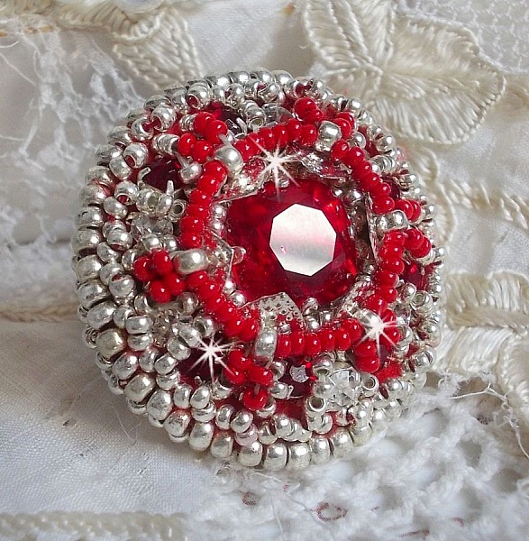 Drigon Red ring broderad med en r&ouml;d Swarovski-kristallcabochon, silverb&auml;lten och fr&ouml;p&auml;rlor.