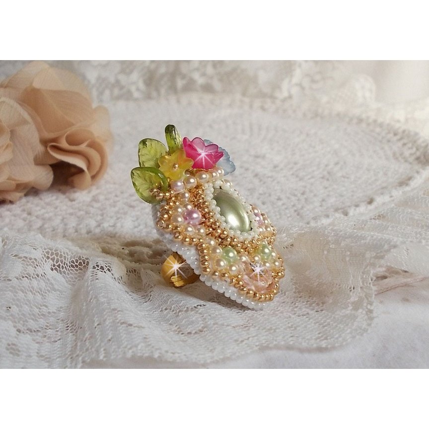 Envolée Fleurie ring broderad med en harts cabochon av Lucite blommor, pärlpärlor och fröpärlor.