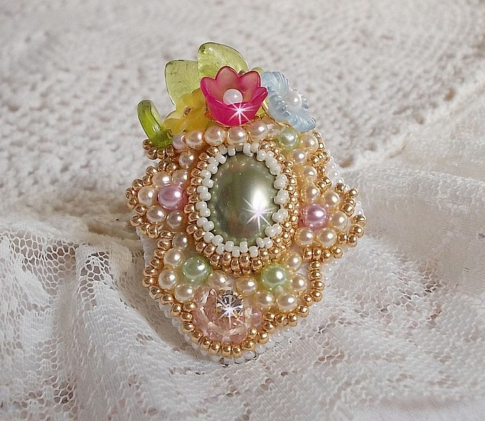 Envol&eacute;e Fleurie ring broderad med en harts cabochon av Lucite blommor, p&auml;rlp&auml;rlor och fr&ouml;p&auml;rlor.