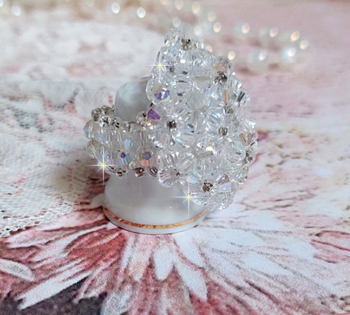 Flockring med facetter och snurrande toppar i Swarovski-kristall