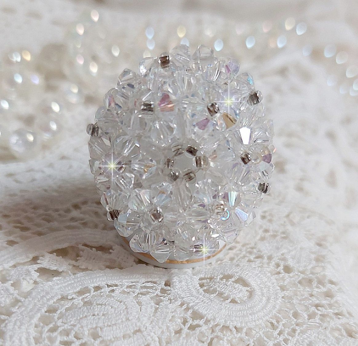 Flockring med facetter och snurrande toppar i Swarovski-kristall